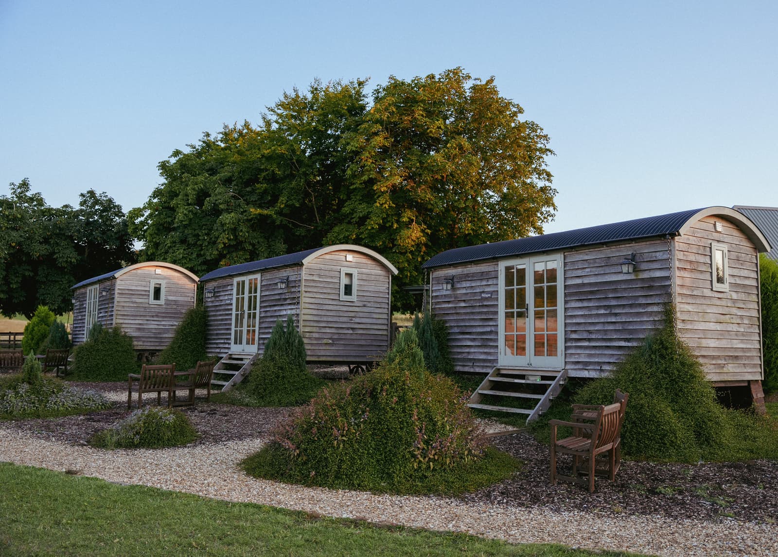 The Wellington, Baacombe and Horsecombe shepherd huts together under the trees