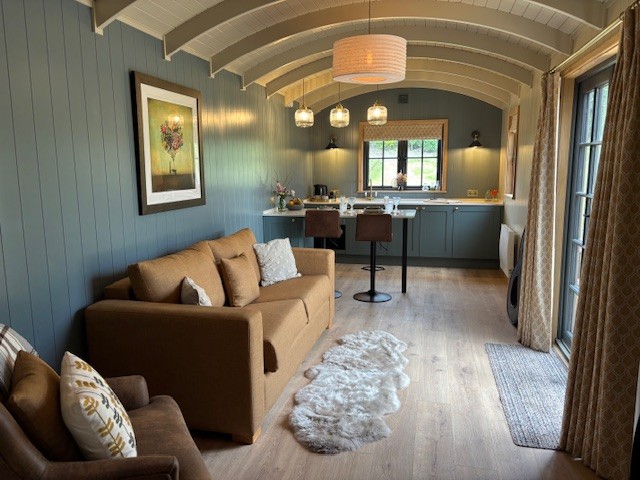 The Meadow Suite living space, sofas and kitchen under the beamed ceiling