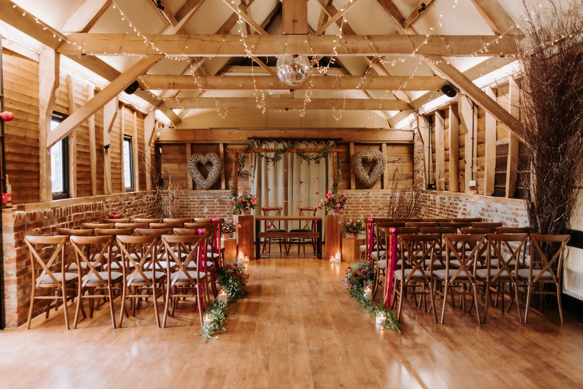 The Old Barn dressed for a ceremony, candles down the aisle